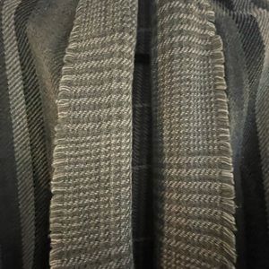 One size fits all.  Light weight reversible wrap/cape.